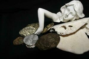 Mermaid laying On Shells Touching Coins From A Treasure Chest. photo