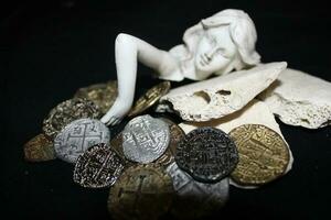 Mermaid laying On Shells Touching Coins From A Treasure Chest. photo