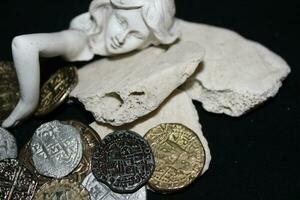 Mermaid laying On Shells Touching Coins From A Treasure Chest. photo