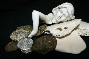 Mermaid laying On Shells Touching Coins From A Treasure Chest. photo