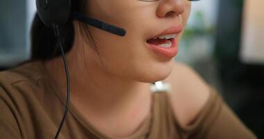 Young Asian woman wearing glasses using a laptop on a desk photo