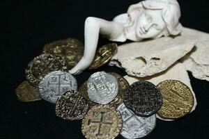 Mermaid laying On Shells Touching Coins From A Treasure Chest. photo