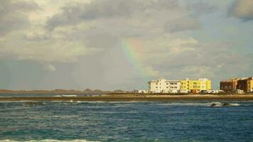 landschap met een regenboog over- de kust, een kust- stad Aan de horizon. video