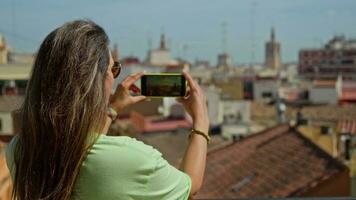 a menina leva As fotos do a panorama do valencia em dela telefone video