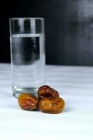 Dates and a glass of water isolated on a white background photo