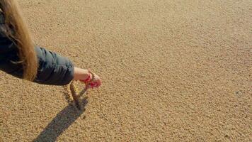 un niña sorteos un corazón en el playa. video