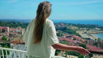 A woman posing on a balcony with a view of the city skyline in the background video