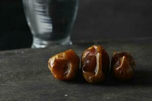 Dates and a glass of water isolated on a black background photo
