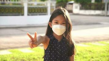 Portrait Asian kid wearing medical mask. A girl wearing mouth mask against air smog pollution. Concept of corona virus quarantine or covid-19.Protection against virus and infection control concept. video