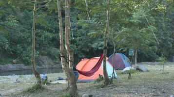 Beautiful morning landscape with camping tent on the river at sunrise photo