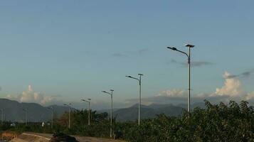 street lamp in the countryside with mountains in the background photo