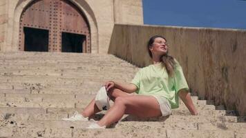 das Mädchen sitzt auf das Schritte von das valencianisch Fort. video