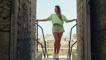 el niña soportes en el puerta de el castillo, admirativo el puntos de vista de el antiguo ciudad video