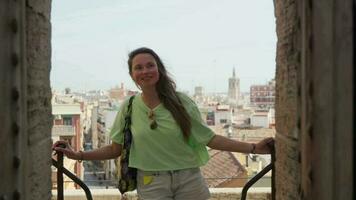 The girl stands in the arch inside the castle, behind the panorama of the city video