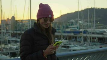 en flicka läser en text meddelande på solnedgång video