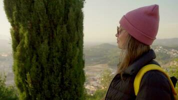 A tourist girl walks along the alley against the background of the city video