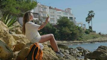 A woman capturing a moment on a rocky landscape in Terragona video