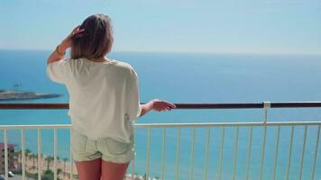 ein Frau genießen das Aussicht von das Ozean von ein Balkon video