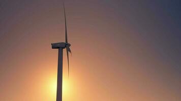 Wind turbines on the background of a red sky, side view. video