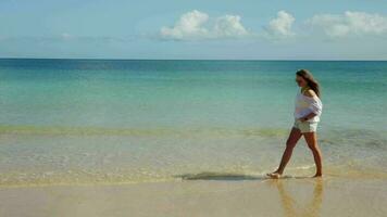 The girl walks along the shore, clear water, a heavenly place. video