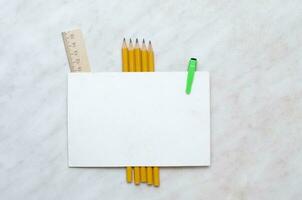 Top view of colorful school supplies with a blank paper for mock up or text. photo