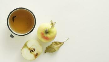 un antiguo metal taza de manzana jugo y manzana composición en blanco fondo.superior vista plana foto