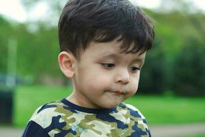 Cute Asian Pakistani Baby is Enjoying The Beautiful Sunny Day at Wardown Children and Public Park of Luton Town of England UK. Low Angle  Image Was Captured on April 03rd, 2023 photo