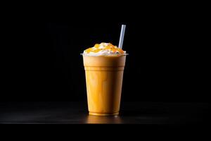 Mango smoothie milkshake in plastic takeaway cup isolated on dark background. photo