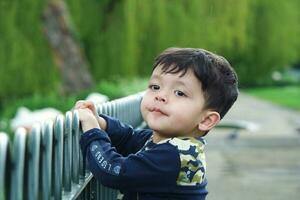 Cute Asian Pakistani Baby is Enjoying The Beautiful Sunny Day at Wardown Children and Public Park of Luton Town of England UK. Low Angle  Image Was Captured on April 03rd, 2023 photo