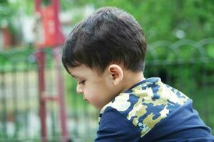 Cute Asian Pakistani Baby is Enjoying The Beautiful Sunny Day at Wardown Children and Public Park of Luton Town of England UK. Low Angle  Image Was Captured on April 03rd, 2023 photo