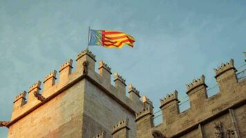 le drapeau de Valence en volant sur le forteresse la tour de le ville. video