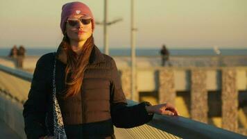 portrait de une fille dans chaud vêtements en marchant le long de le jetée video