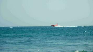 uma vermelho barco corre através a ondas. video