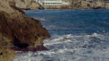 Big waves crash against the rocky shore video