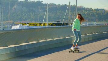A girl rides a skateboard along the yachts video