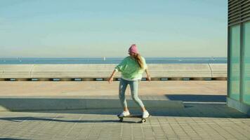 uma menina passeios uma skate contra a pano de fundo do a mar. video