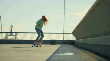 uma menina passeios uma skate a partir de longe video