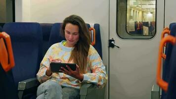 une femme en utilisant une tablette tandis que séance sur une train video