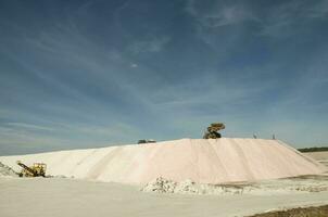 Trucks unloading raw salt bulk, Salinas Grandes de Hidalgo, La Pampa, Argentina. photo