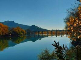 Autumn landscape with blue lake and trees on the shore photo