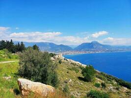 ver desde el mar a el montañas y el azul cielo con nubes foto