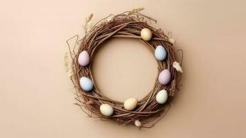 Wreath with eggs. Wreath made of willow twigs and Easter eggs on a pastel background. photo