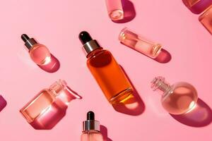 Background with bottles of perfume. Natural oil cosmetics with shadows on a pink background. photo