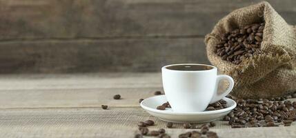 un taza de café. café frijoles en un de madera antecedentes. Copiar espacio. bandera foto