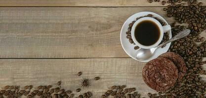 Fresh coffee. A cup of fresh aromatic coffee. Coffee cookies. Grains on a wooden background. View from above. Copy space. Banner photo