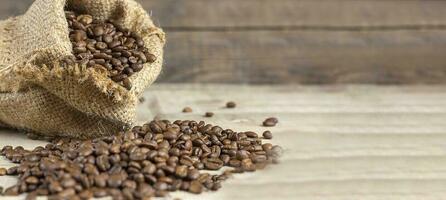 Fresh coffee beans in bags on a wooden background. Copy space. Banner photo