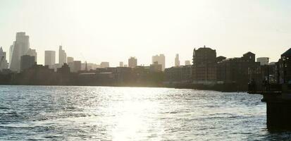 bajo ángulo ver de central Londres edificios y río Támesis a canario muelle central Londres. el imágenes estaba capturado durante puesta de sol terminado Londres ciudad de Inglaterra Reino Unido en junio 08, 2023 foto