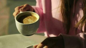 un niña bebidas café desde un pequeño taza en un café video