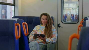 A woman using a tablet while sitting on a train video