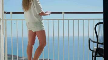 un mujer disfrutando un escénico ver de el Oceano desde un balcón video